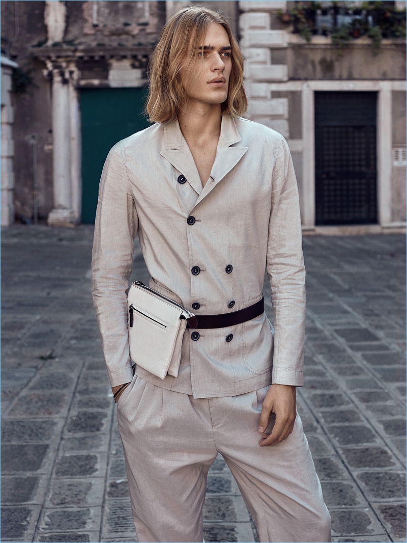 Taking to the streets of Venice, Ton Heukels dons a double-breasted Giorgio Armani suit with a Canali bag.