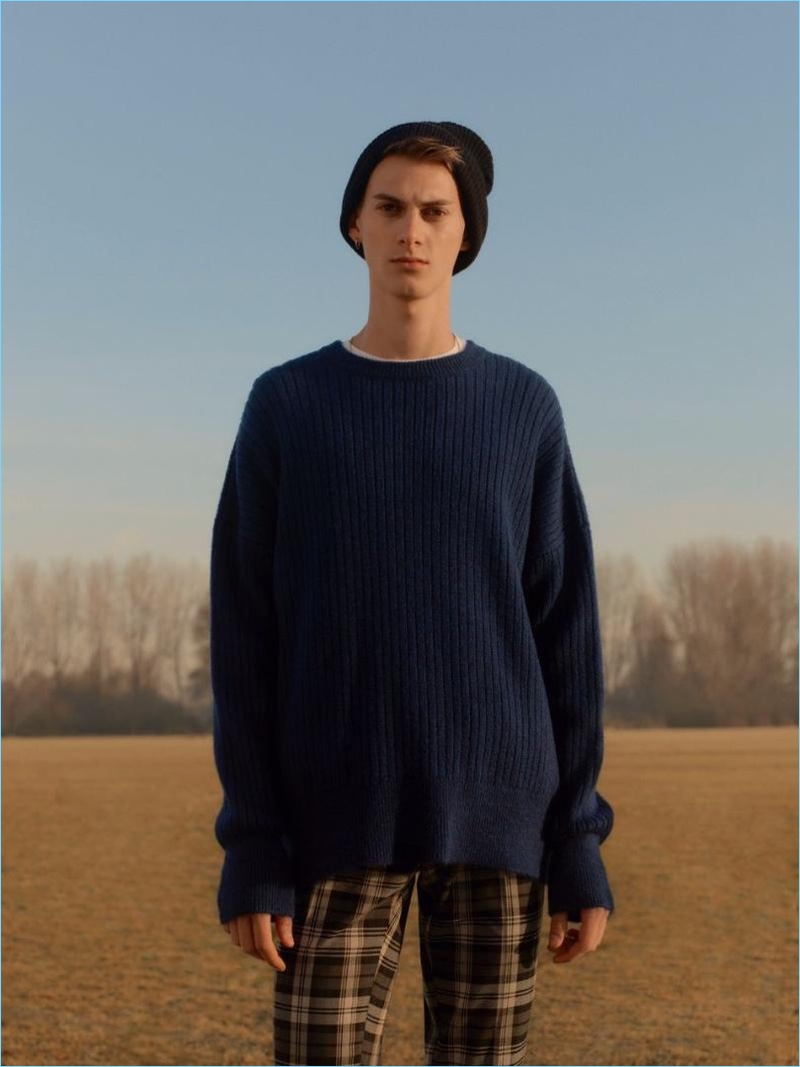 Derian Unterweger rocks a navy ribbed drop shoulder sweater with plaid pants by Topman.