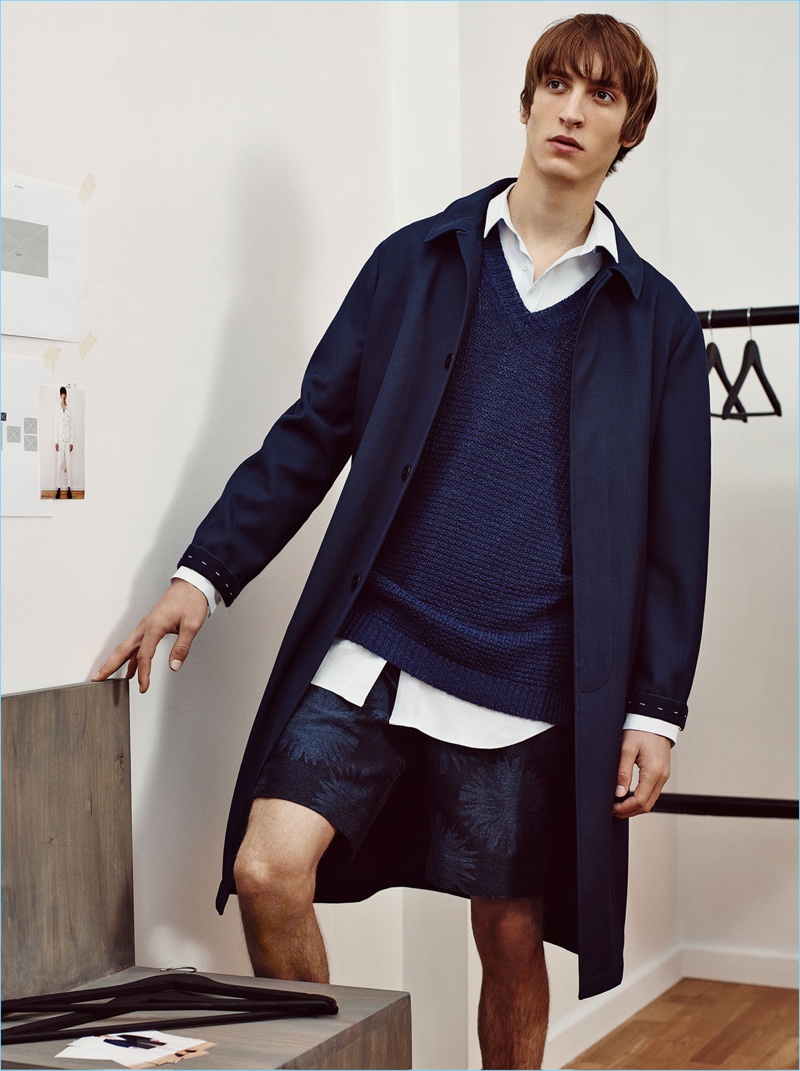 Embracing navy, Tim Dibble wears a studio overcoat, linen vest, and Bermuda shorts from Zara Man.