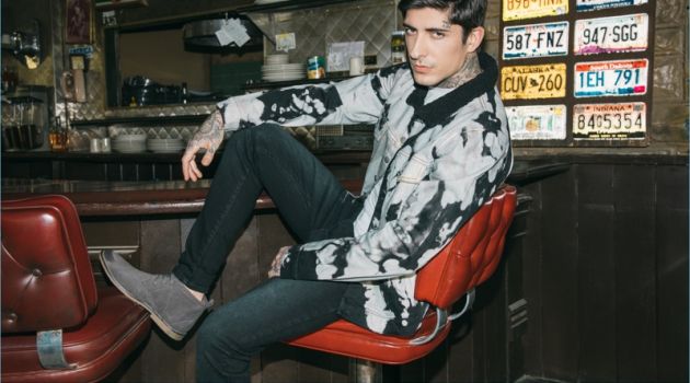 Relaxing at a diner, Daniel Bamdad sports a bleached jacket with distressed jeans and chukka boots from boohooMAN.