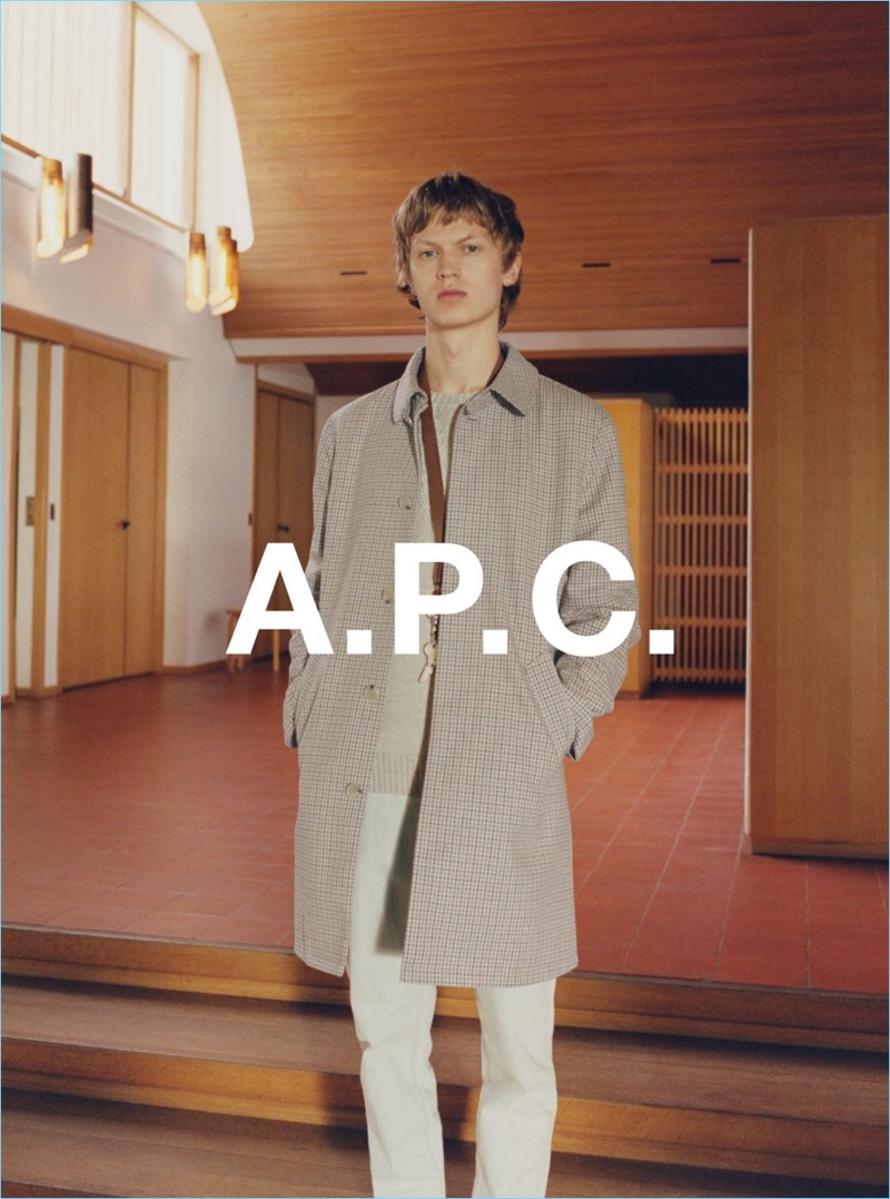 Starring in A.P.C.'s spring-summer 2017 campaign, Jonas Glöer wears light washed slim-fit denim jeans $250 with a plaid single-breasted coat.
