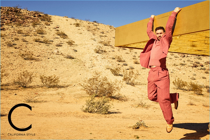 Taking to the desert, Aaron Taylor-Johnson sports a Bottega Veneta sweater and suit with Santoni shoes.