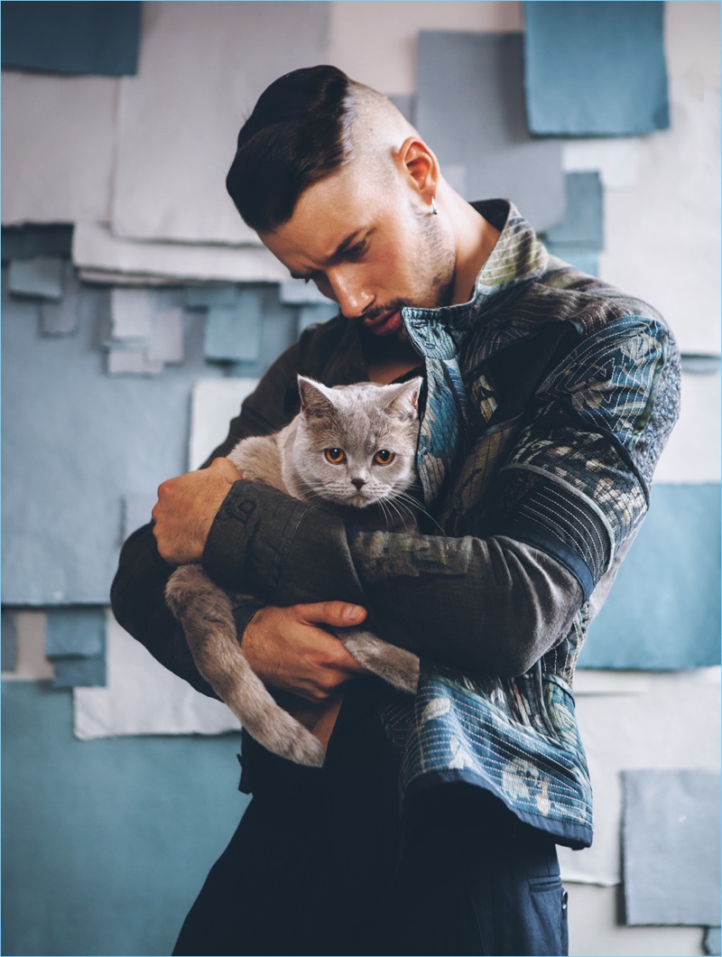 Holding a cat, Nahel Drici models fashions by Dries Van Noten.