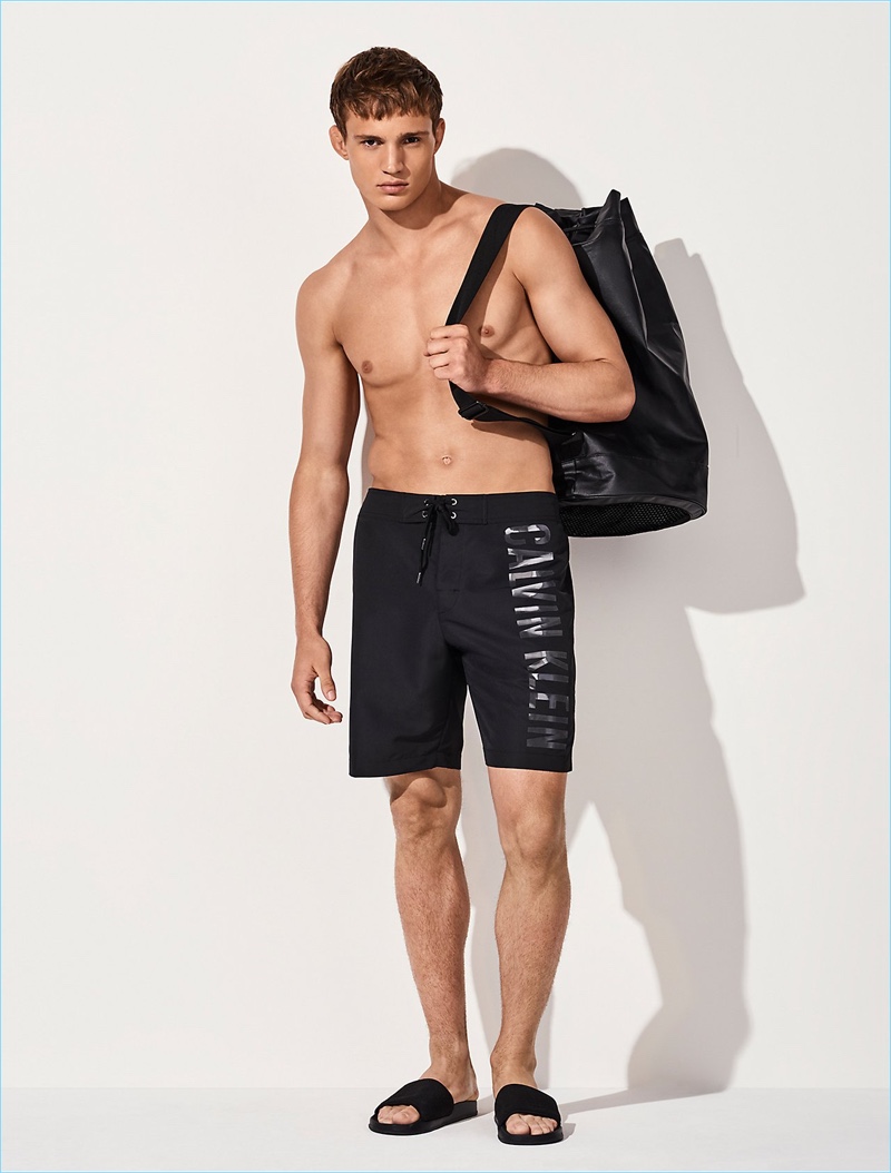 Going simple in black, Julian Schneyder wears Calvin Klein embossed board shorts $85.