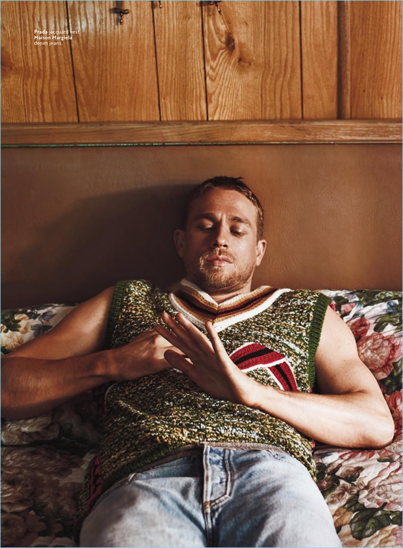 Resting in bed, Charlie Hunnam rocks a Prada vest with Maison Margiela denim jeans.