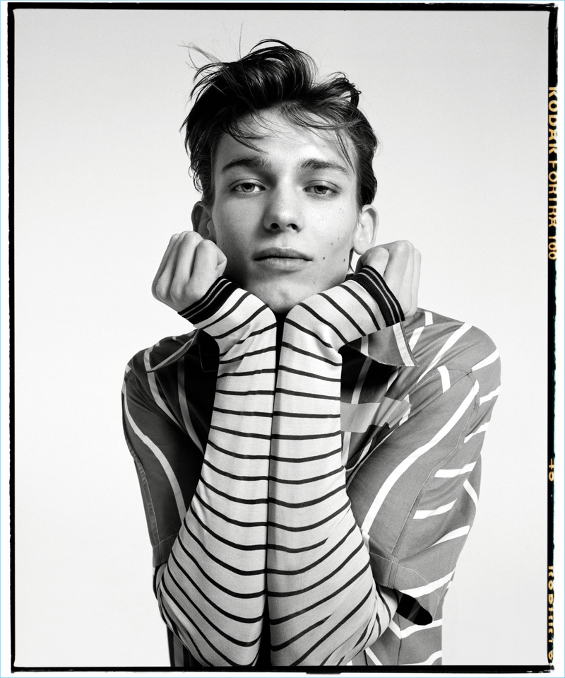 Front and center, Christopher Einla wears a striped Lanvin shirt and t-shirt.