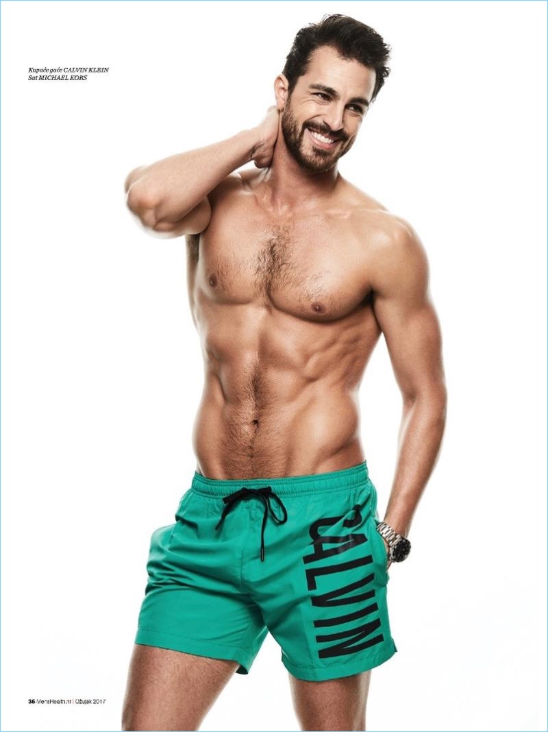 Ready for swim season, Clint Mauro wears green Calvin Klein swim shorts with.