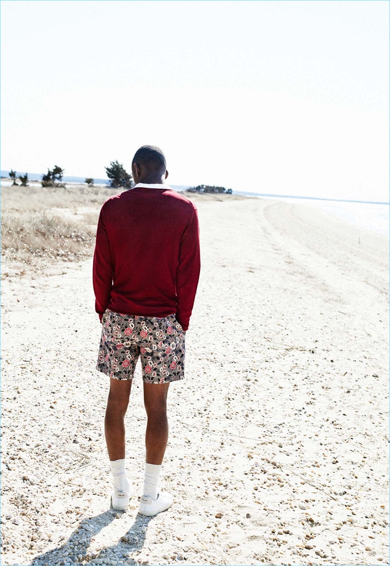 Connecting with Club Monaco, Lucas Cristino sports a polo $120, linen sweater $129.50, floral batik print shorts $89.50, and Veja Esplar sneakers $120.