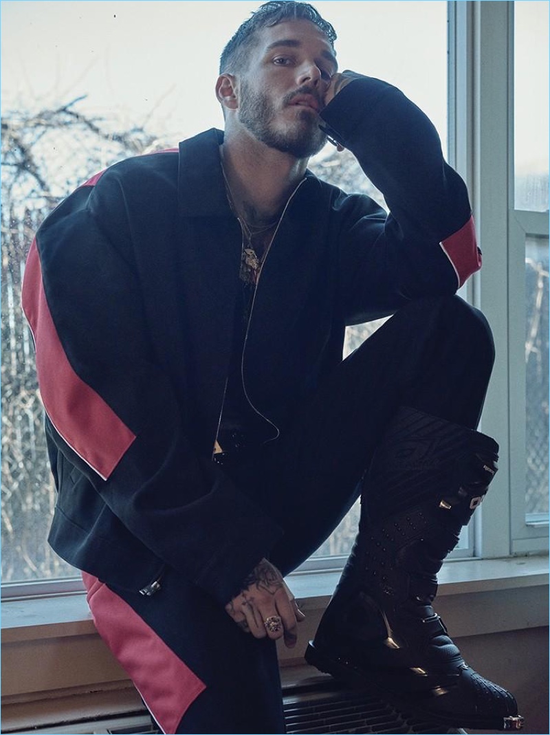 David Alexander Flinn sports a red and black moto jacket with matching pants by Alexander Wang. The model also sports O'Neal boots.