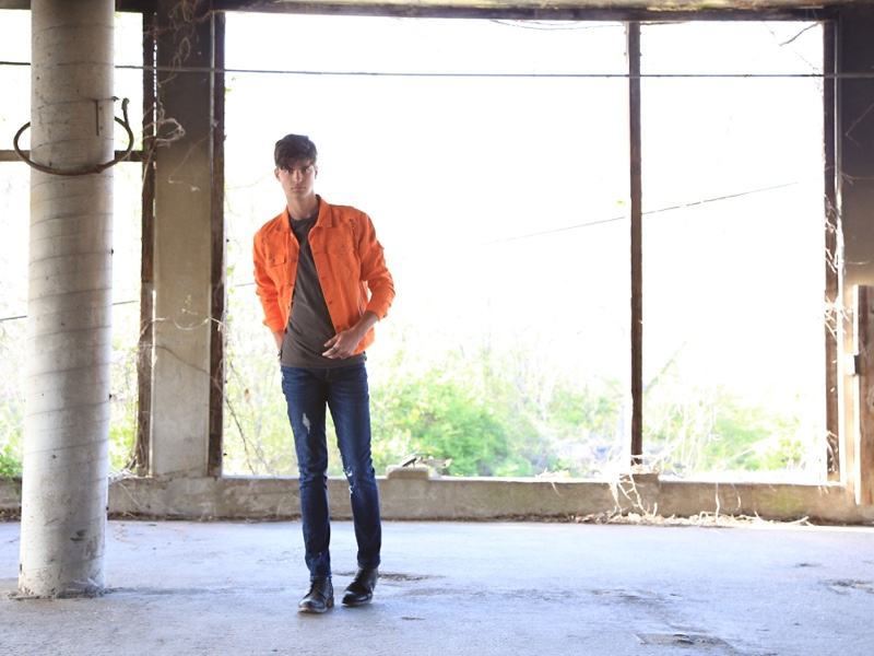 Joshua wears orange denim jacket Ralph Lauren, t-shirt Urban Outfitters, jeans Lucky Brand, and boots Rule London.