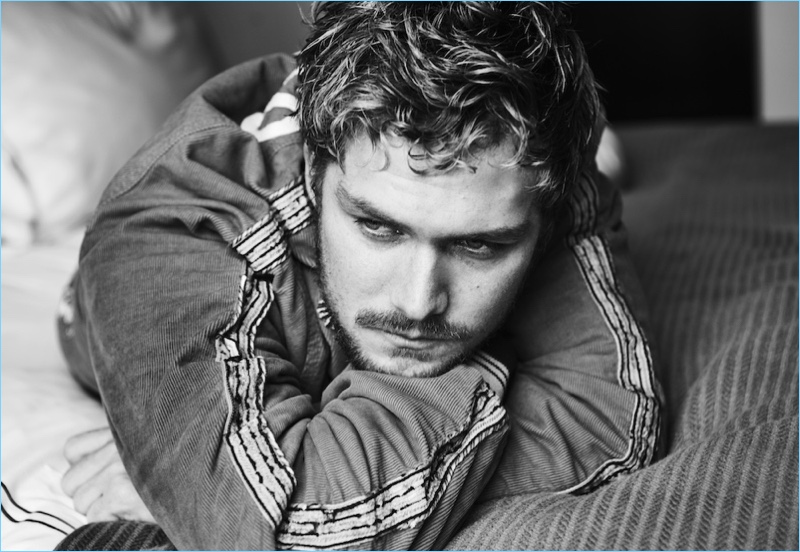 Stealing a quiet moment, Finn Jones wears a jacket and pants by Gucci.