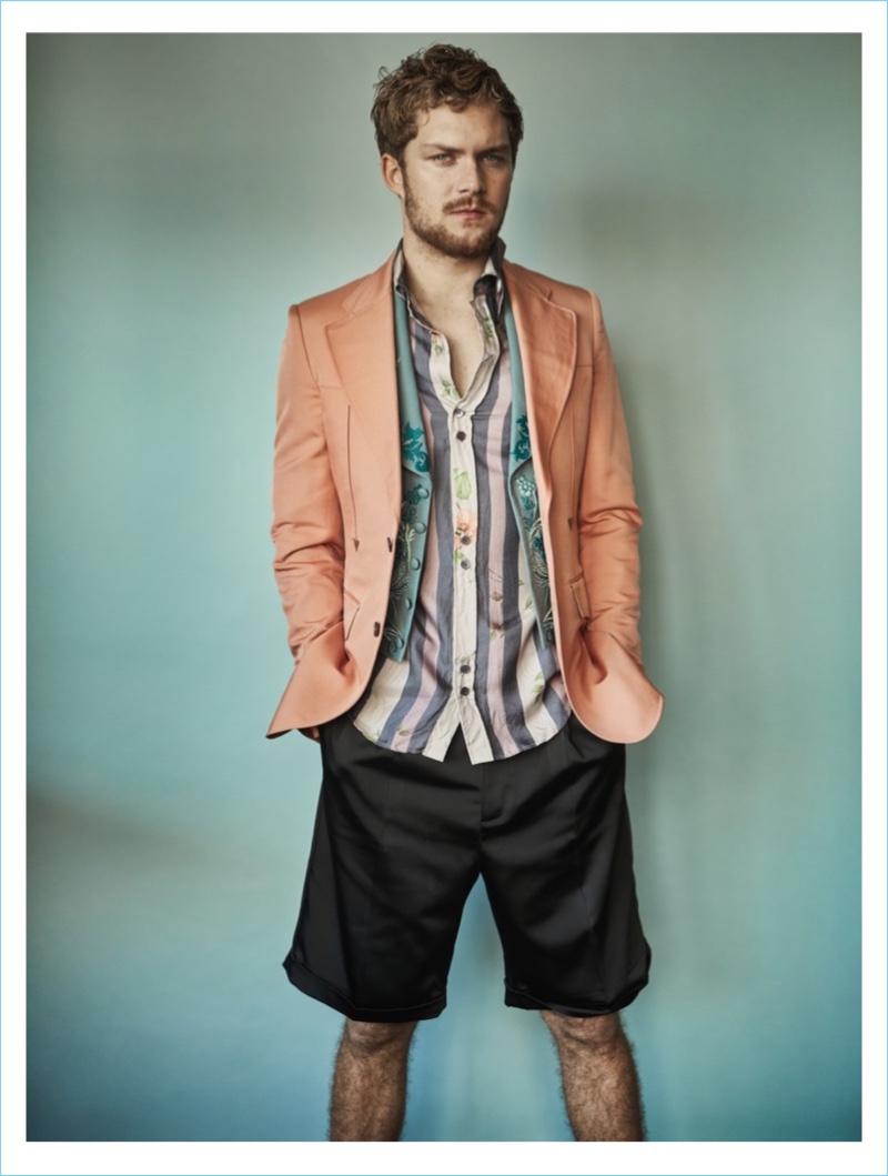 Actor Finn Jones sports a jacket, waistcoat, and shirt by Roberto Cavalli with shorts from The Kooples.