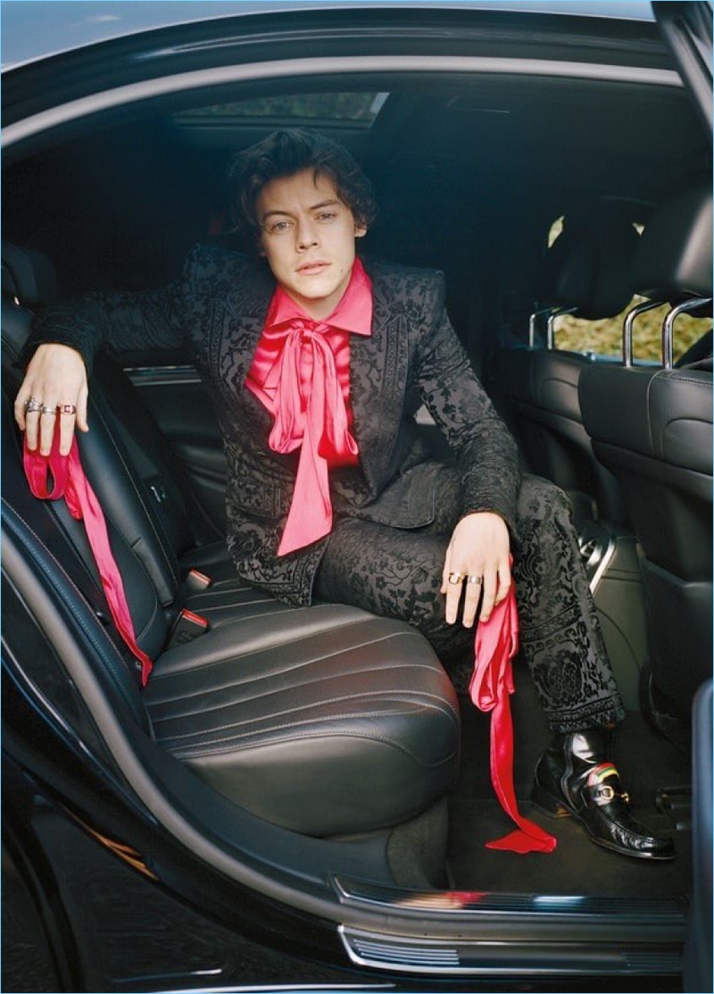 Singer Harry Styles embraces a dandy flair in a brocade suit with a pink shirt and bow for Rolling Stone.