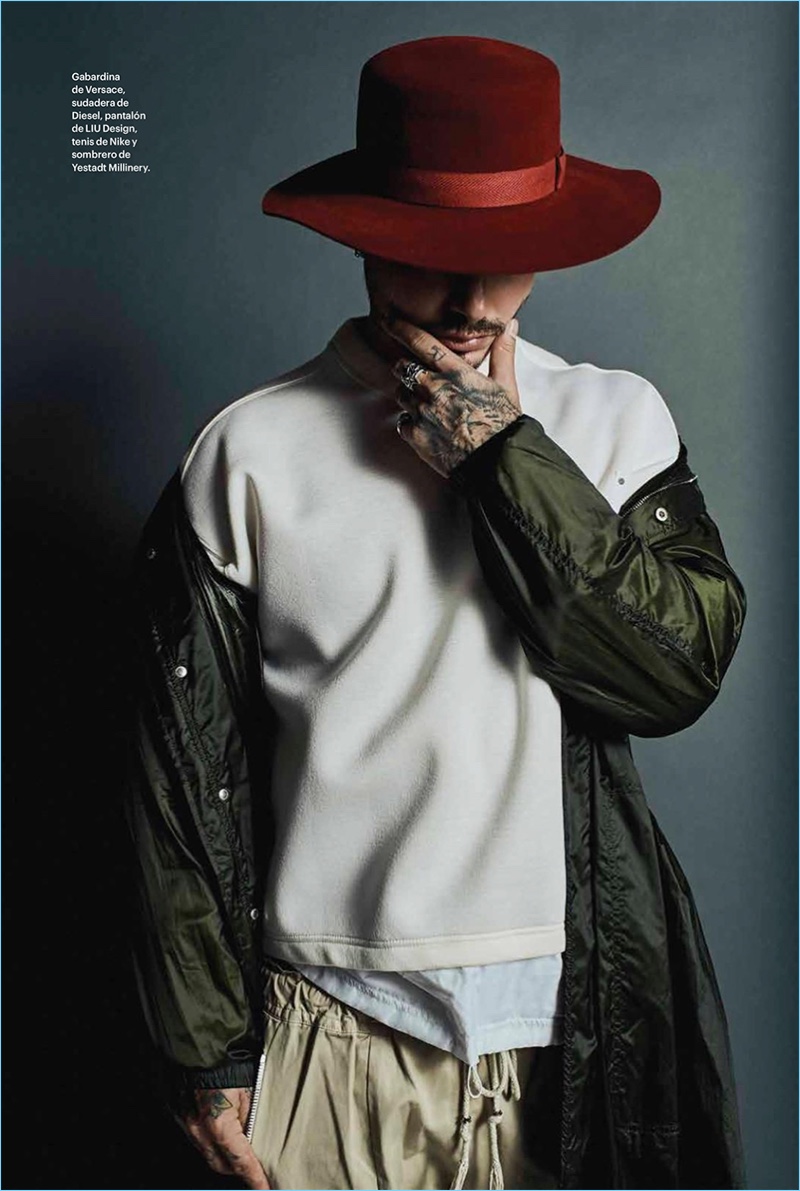 Front and center, J. Balvin wears a Versace parka with a Diesel sweater, LIU Design pants, and a Yestadt Millinery hat.