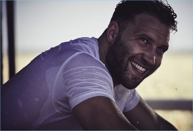 All smiles, Jai Courtney sports a Commas white t-shirt.