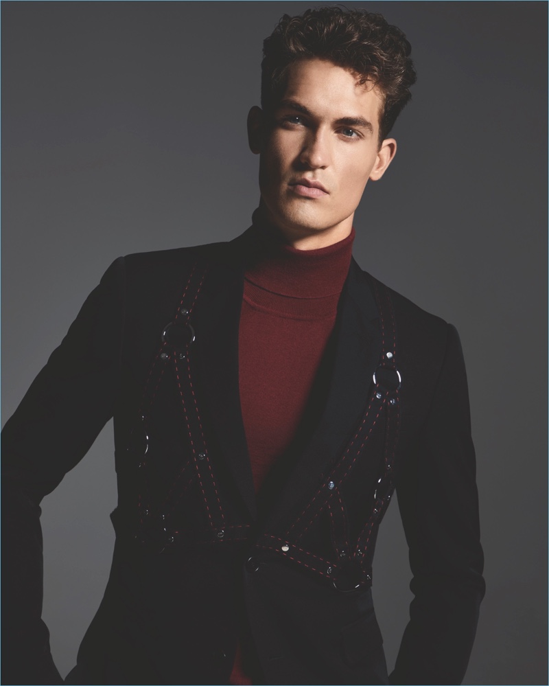 A rebellious vision, Jason Anthony sports a Dior Homme jacket with a harness detail and Hugo Boss turtleneck sweater.