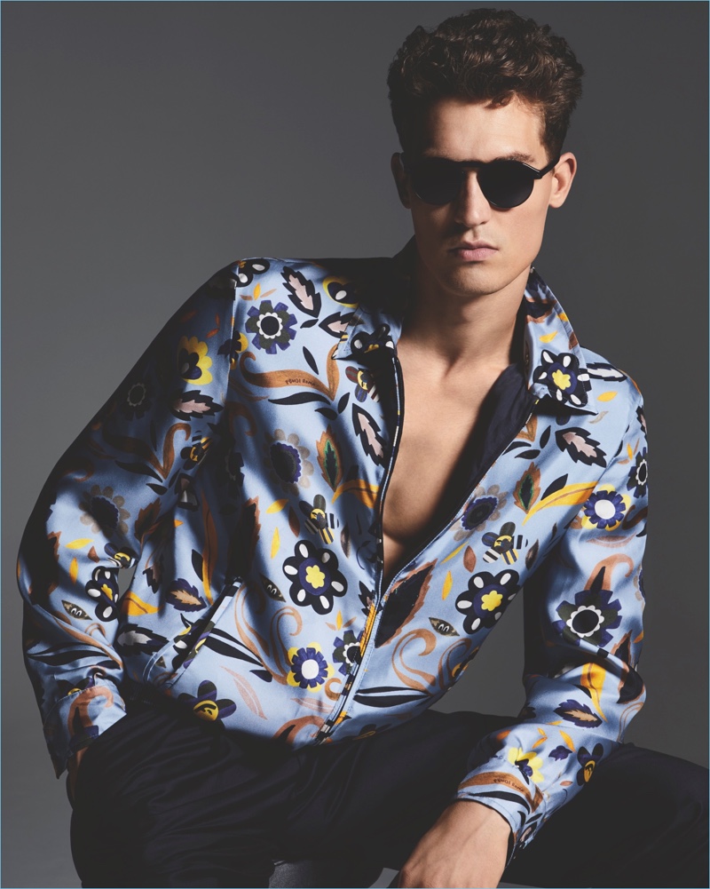 Model Jason Anthony wears a Fendi graphic print silk bomber jacket with Giorgio Armani trousers and sunglasses.