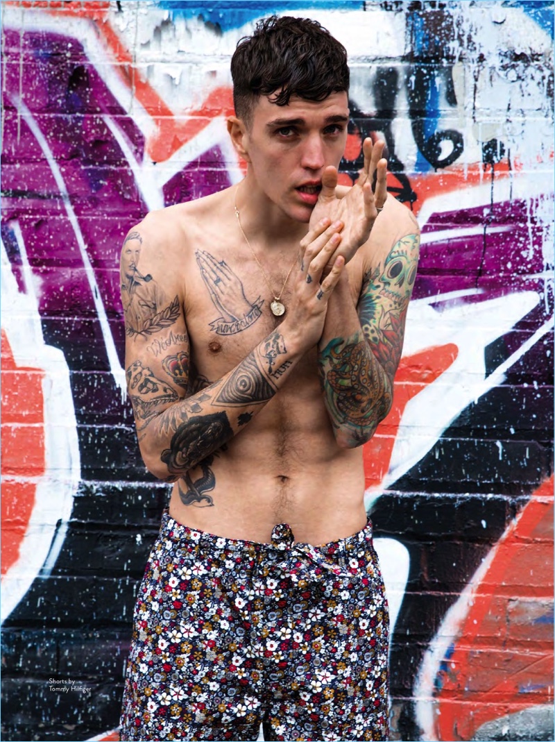 Going shirtless, Josh Beech wears floral print shorts by Tommy Hilfiger.