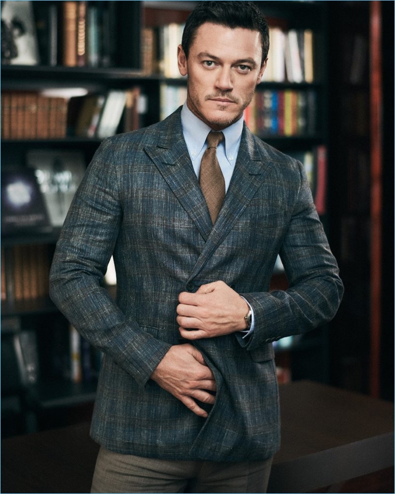 Donning a double-breasted jacket by Dunhill, Luke Evans also wears a Turnbull & Asser shirt, Drake's tie, and Brunello Cucinelli trousers.