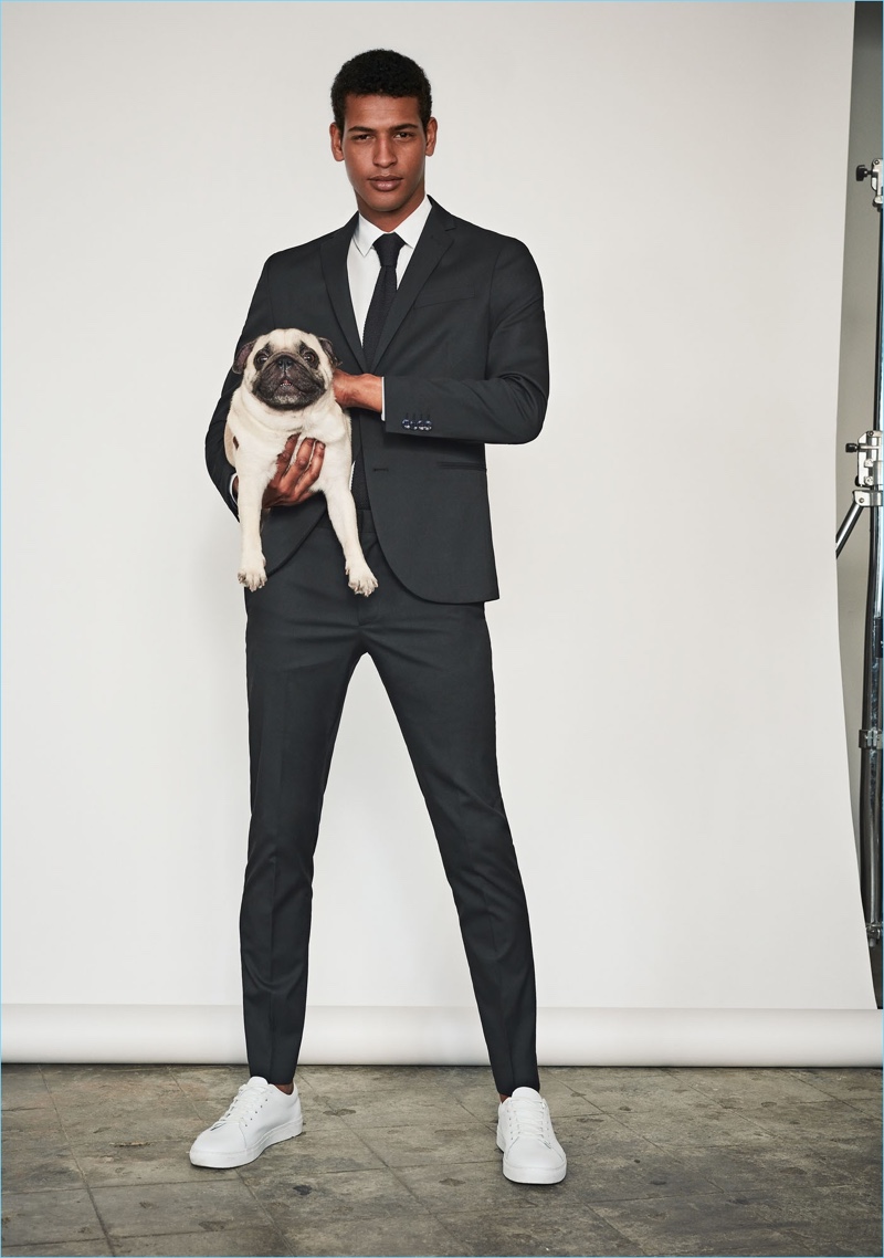 Providing a timeless suiting look, Tidiou M'Baye models a Mango Man modern slim-fit suit blazer $139.99 and trousers $69.99. Tidiou also sports a Mango Man tailored shirt $49.99, textured knit tie $39.99, and lace-up leather sneakers $69.99.