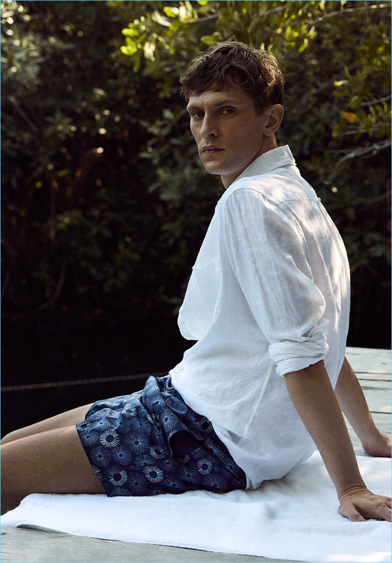 Ready for summer, Mathias Lauridsen wears a white linen shirt with printed shorts.
