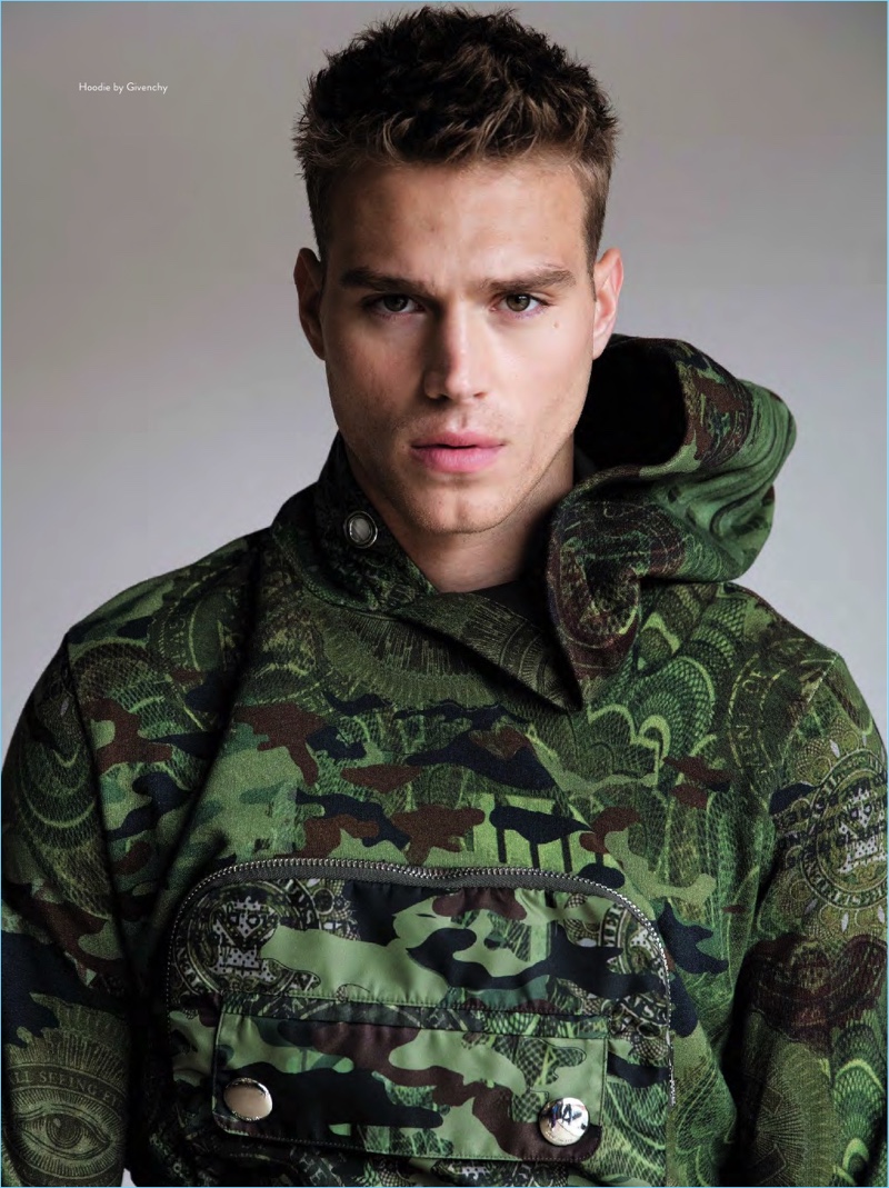 Front and center, Matthew Noszka goes sporty in a camouflage hoodie by Givenchy.