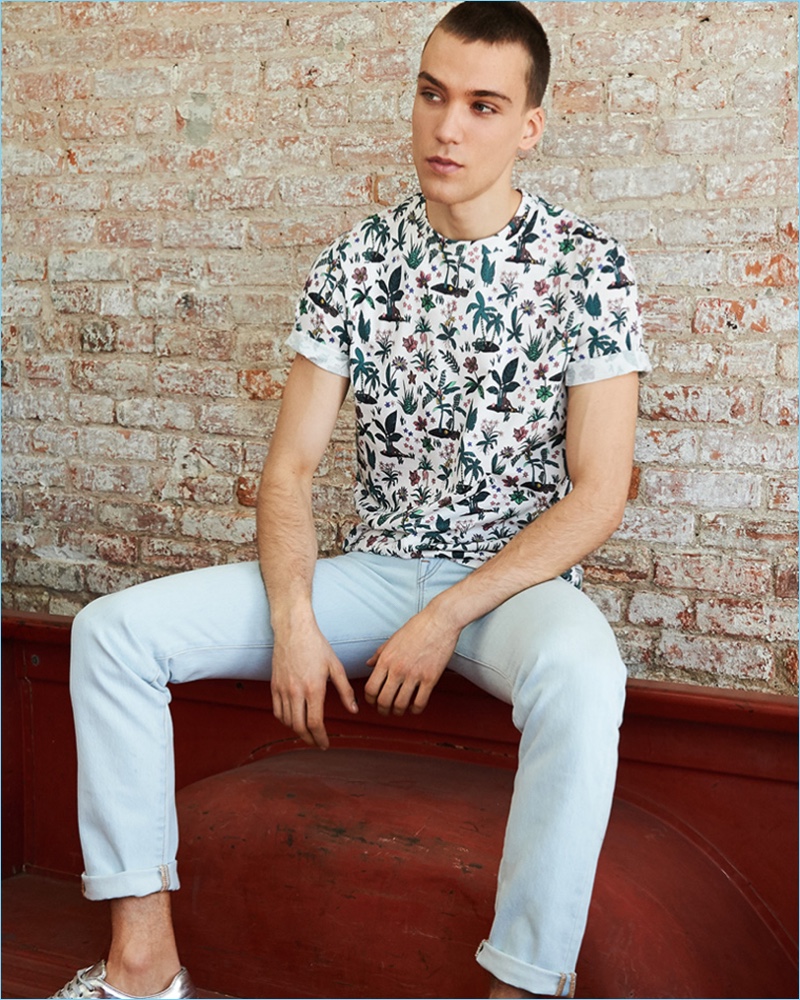 Going casual, Marc Lüloh wears an allover floral print tee and tapered jeans from PS by Paul with Paul Smith metallic leather sneakers.