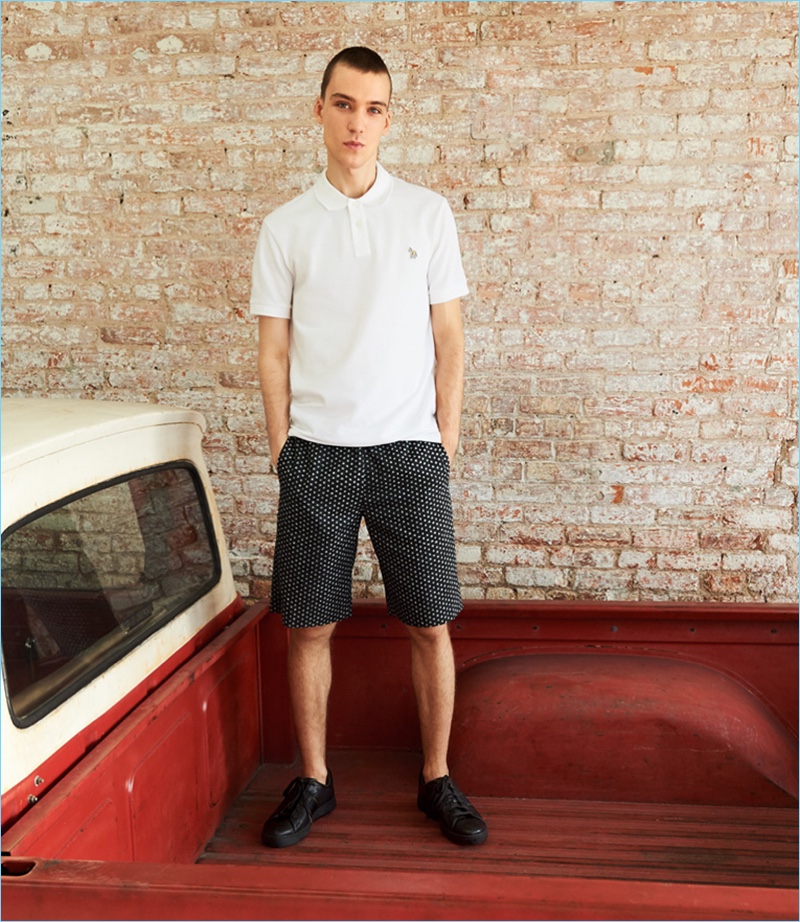 Front and center, Marc Lüloh rocks a regular fit polo, black dot shorts, and sneakers from PS by Paul Smith.