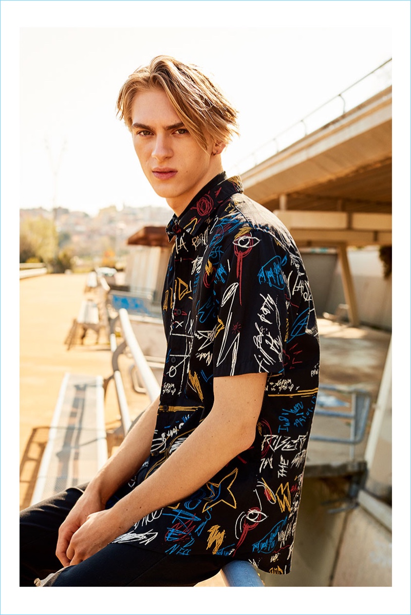 Sporting a colorful graphic shirt, Dominik Sadoch stars in the summer 2017 campaign of Reserved.