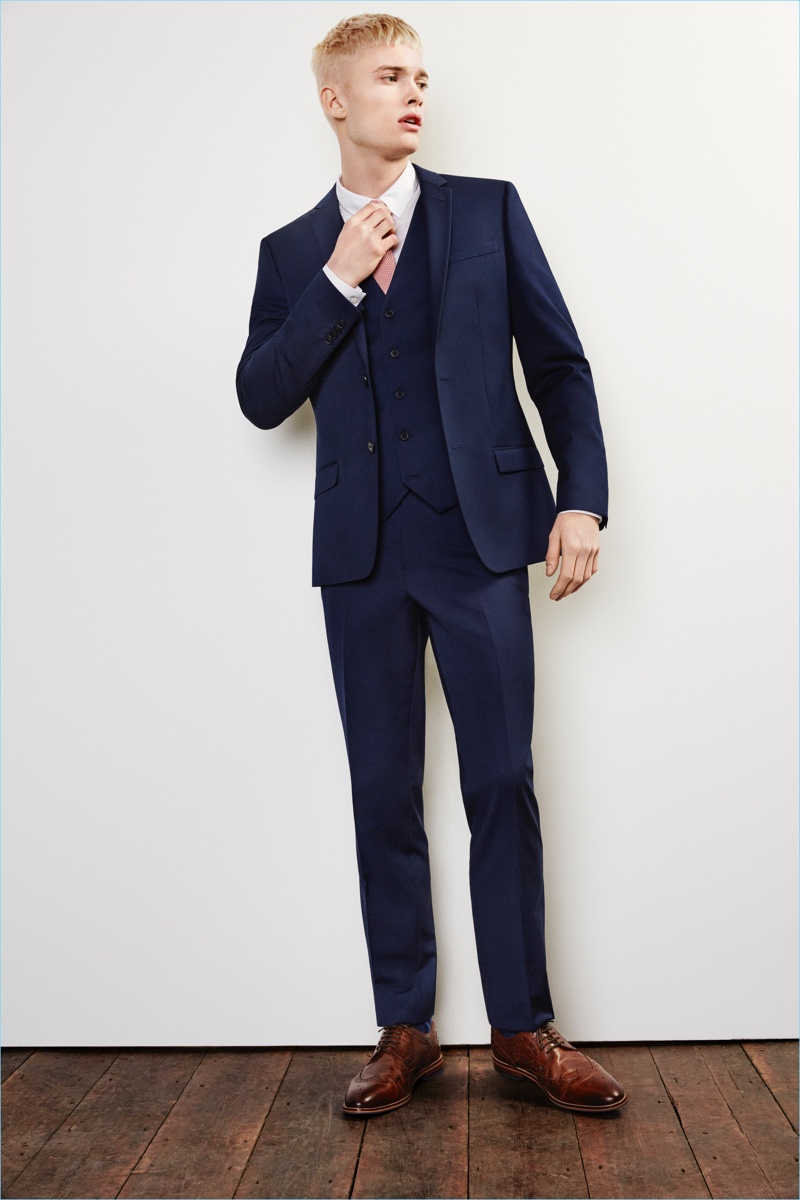 Make a classic statement in a dark blue River Island slim-fit suit jacket $130, vest $70, and pants $70.