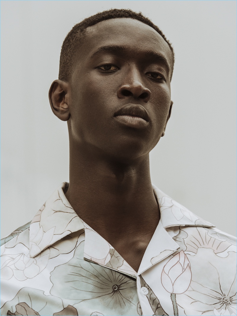 Model Fallou Diaw wears a floral print shirt from Saturdays NYC's pre-fall 2017 collection.