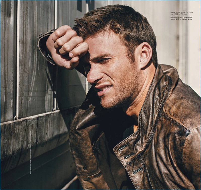 Appearing in a photo shoot for Modern Luxury, Scott Eastwood sports a brown leather jacket by Tod's with a John Varvatos tank.