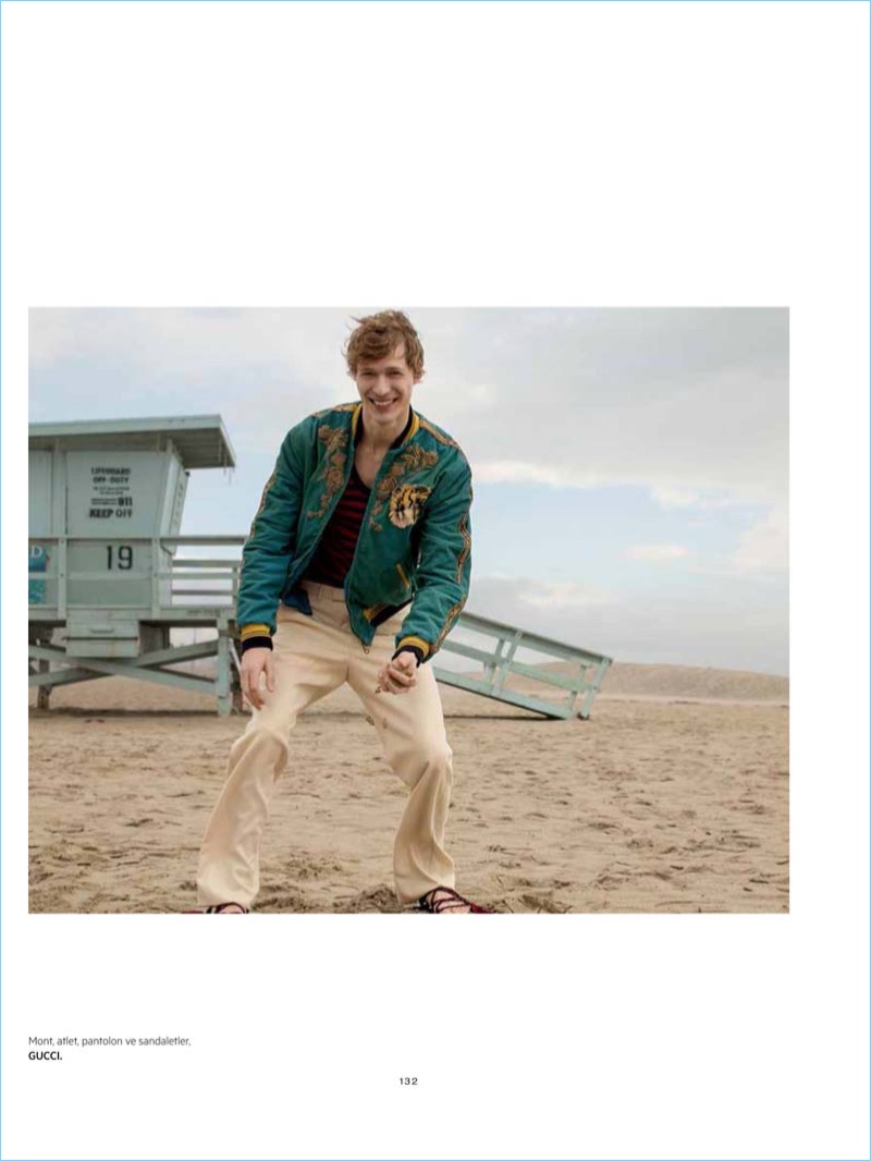 All smiles, Sven de Vries takes to the beach in fashions from Gucci.