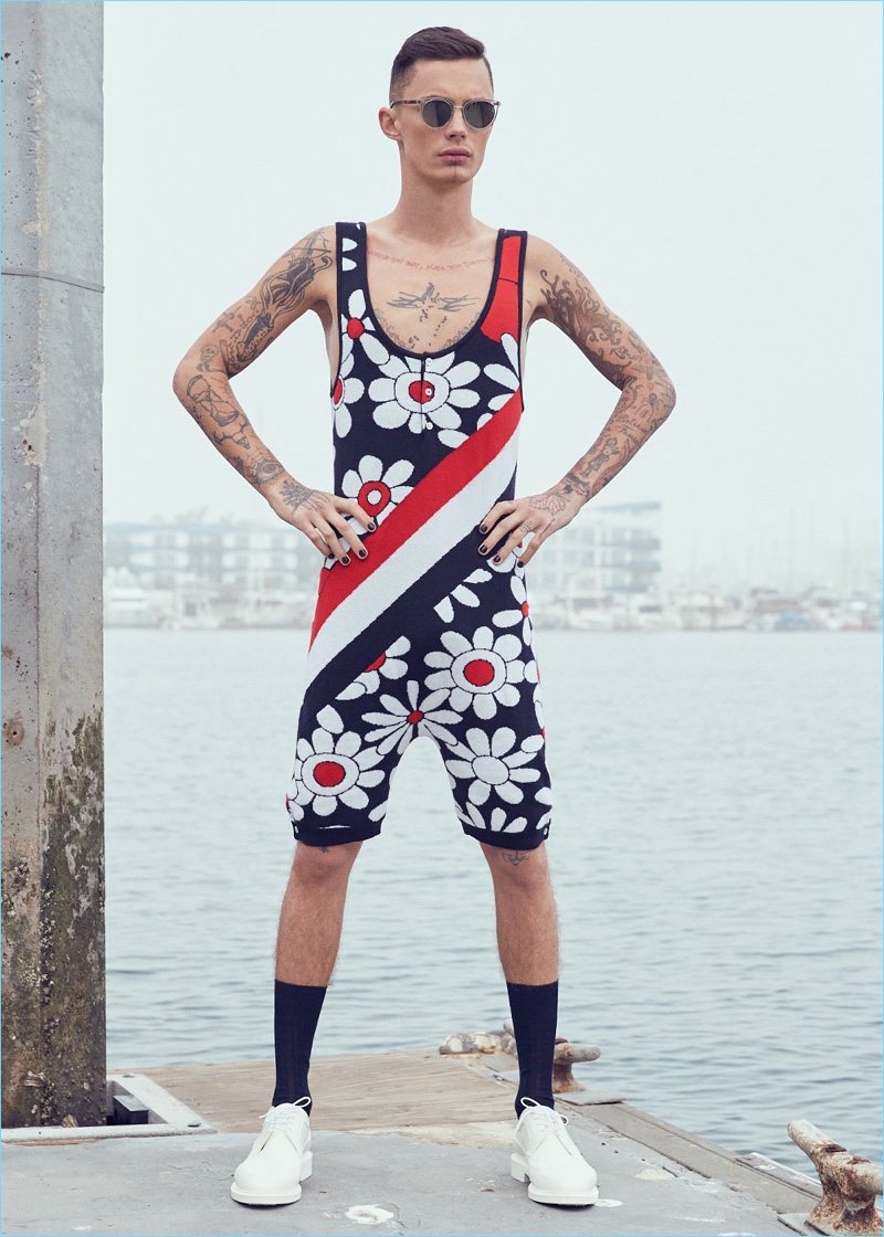 Ready for the beach, Simon Kotyk sports a Thom Browne daisy floral intarsia singlet $3,200, rubber brogues $950, and a shark bag $2,500 with Oliver Peoples Spelman sunglasses $475.