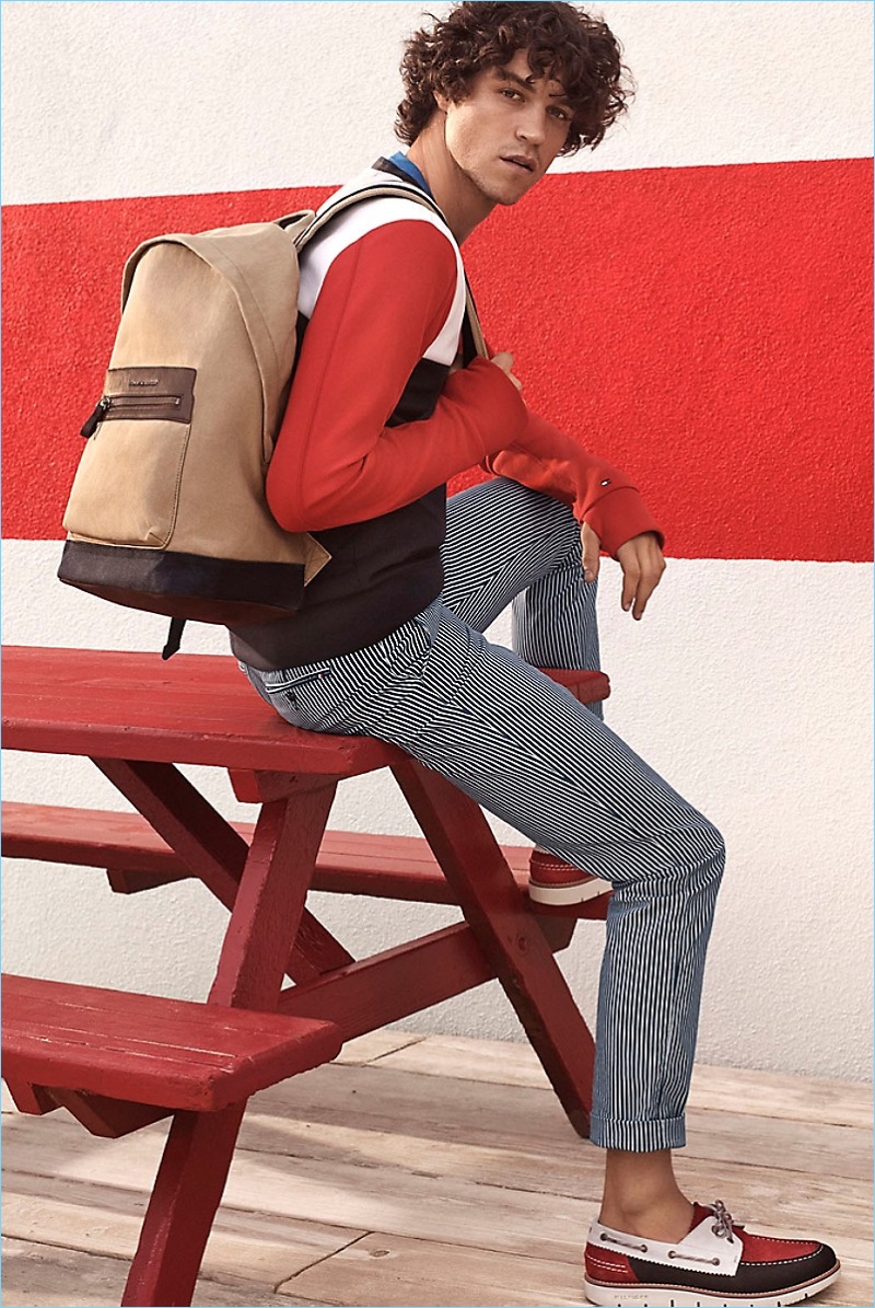 Fresh Canvas: Miles McMillan models a Tommy Hilfiger color block sweater $119.50 and cotton stretch tee $35.50. Miles also sports Tommy Hilfiger pinstripe slim straight chinos $139.50, a washed canvas backpack $129.50, and color block suede deck shoes $129.50.