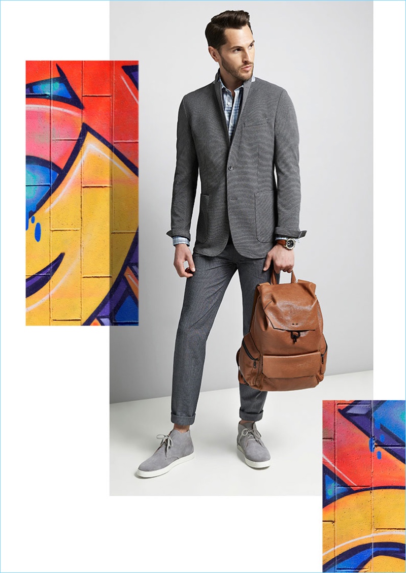 Suiting up, Jake Davies wears a Vince Camuto slim-fit stretch knit blazer $225, 5-pocket stretch pants $98, a trim-fit plaid sport shirt $85, and grey chukka sneakers $195. Jake also takes hold of a brown Vince Camuto Travo leather cargo pocket backpack $378.