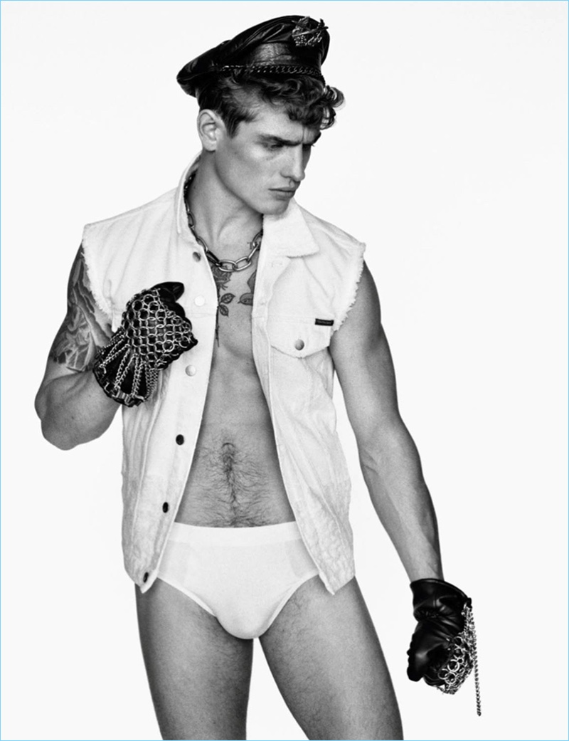 British model Patrick O'Donnell wears a sleeveless denim jacket by Calvin Klein Jeans with a Valentino necklace.