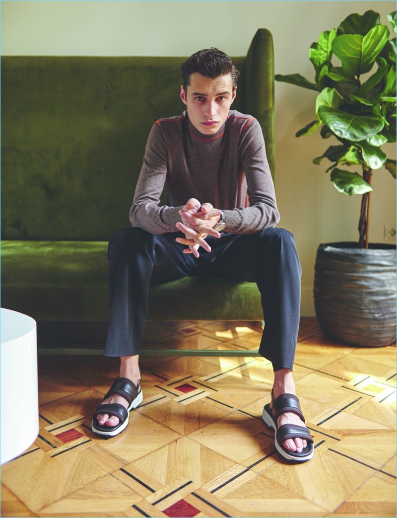 Front and center, Adrien Sahores sports a Prada sweater with Bottega Veneta trousers, Hermes sandals, and a Longines watch.