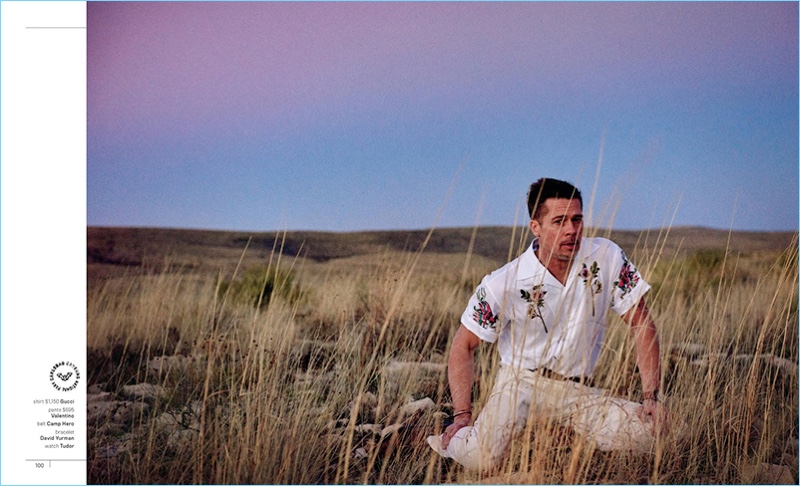 Sitting in a field, Brad Pitt wears a Gucci shirt with Valentino pants. He also dons a Camp Hero belt, David Yurman bracelet, and Tudor watch.