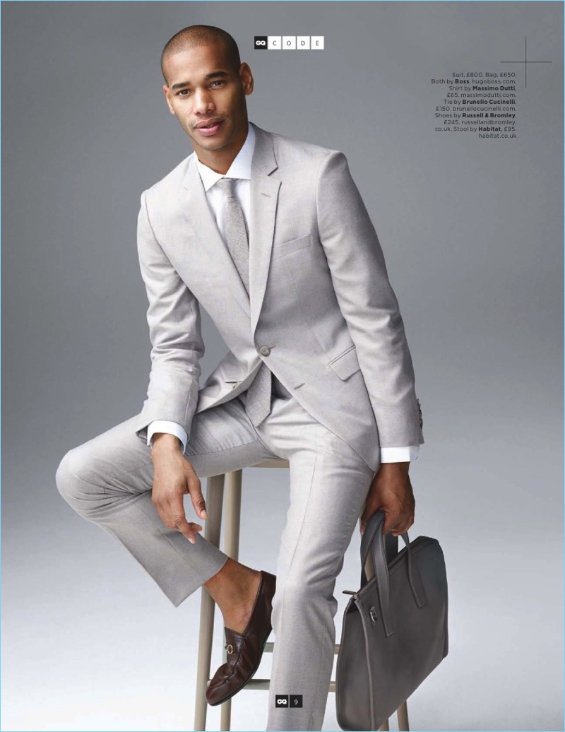 Front and center, Sacha M'Baye models a pale grey suit and bag by BOSS Hugo Boss. The French model also wears a Brunello Cucinelli tie and Russell & Bromley shoes.