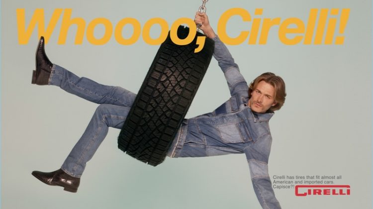 Swinging in a tire, Brad Kroenig wears a denim look by Valentino with Carvil Paris shoes.