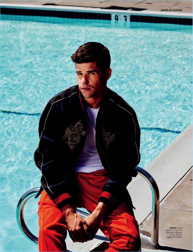 Relaxing poolside, Charlie Carver sports a Gucci jacket with a Diesel tee and Adidas pants.