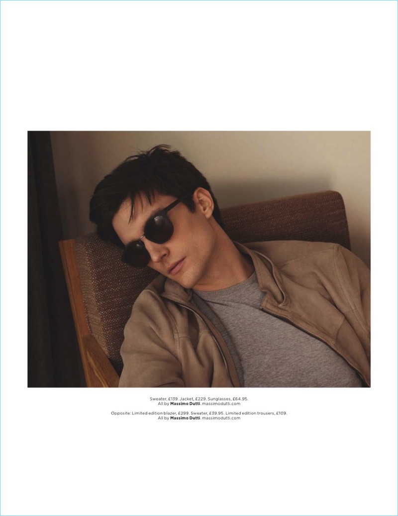 Catching a moment to relax, Charlie Timms sports a sweater, jacket, and sunglasses from Massimo Dutti.