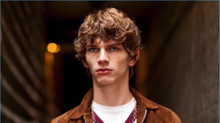 Erik van Gils wears a brown suede jacket by Officine Generale with a Rossignol sweater, and American Vintage t-shit. The model also sports Balibaris pants, and a David Yurman chain necklace.