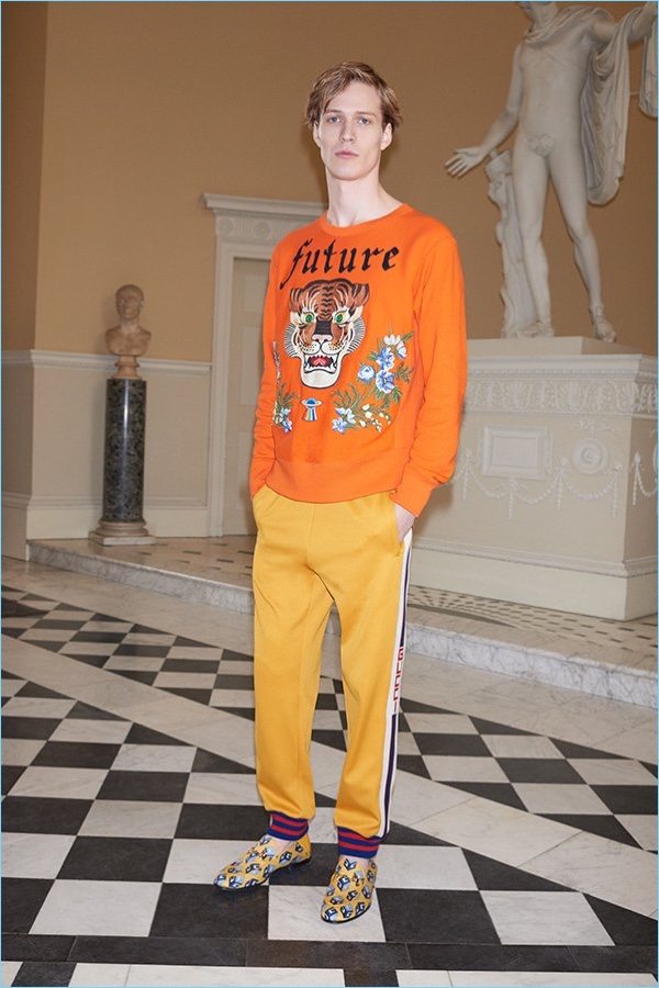 Italian fashion house Gucci brings color to the season with its embroidered tiger sweater $2,450, striped jersey sweatpants $920, and printed satin loafers $650.