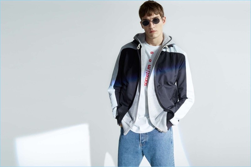 Paying tribute to the nineties, Matvey Lykov embraces skate style. He wears a hooded sweatshirt with a graphic tee, white sneakers, and cropped denim jeans.