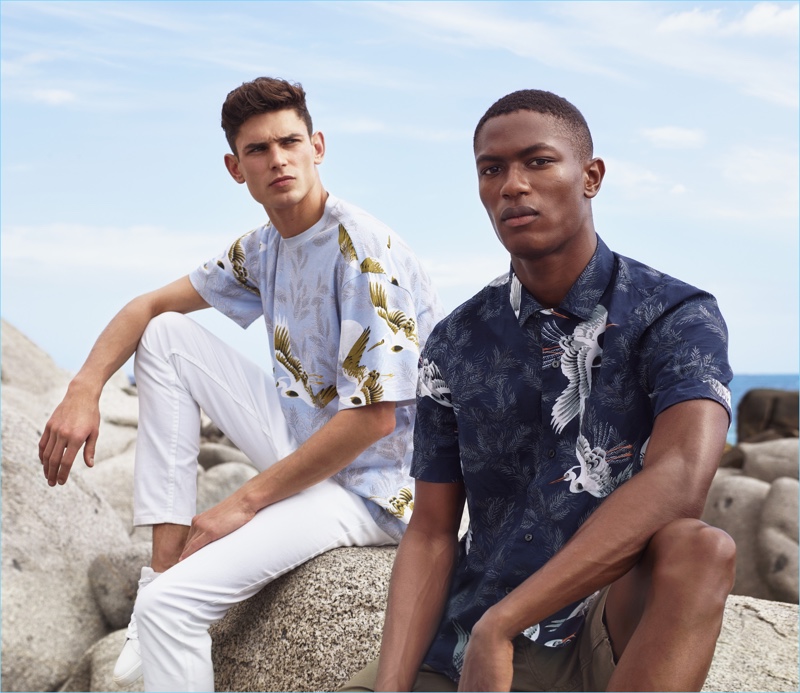 Left to Right: Arthur Gosse wears an oversized graphic t-shirt with white skinny fit twill pants $29.99 and sneakers $24.99. Hamid Onifade rocks a resort shirt $24.99 and short cotton shorts $24.99.