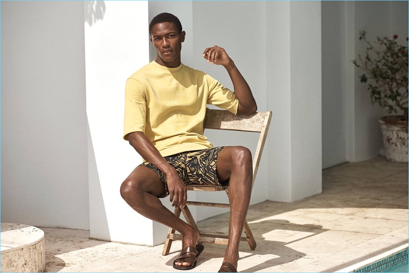 A vision in yellow, Hamid Onifade wears a H&M short-sleeved sweatshirt $19.99 with knee-length cotton shorts $24.99, and slip-on leather mules $39.99.