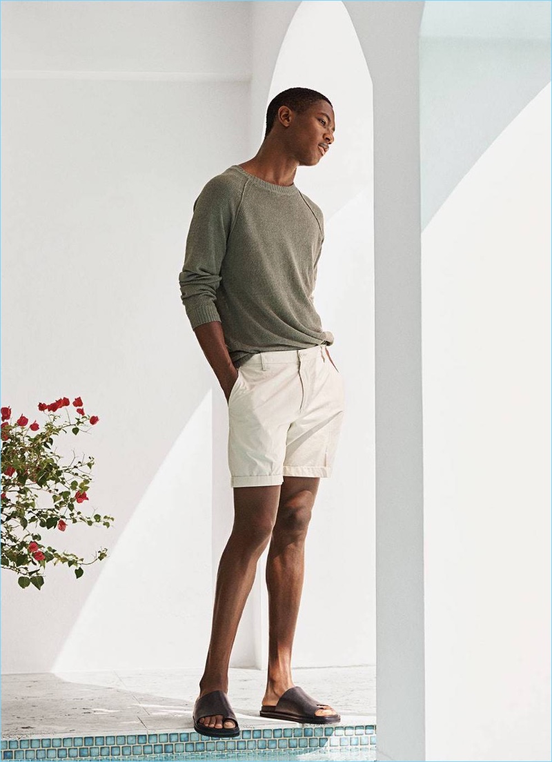 Embracing chic summer styles, Hamid Onifade wears a linen sweater $34.99, short chino shorts $19.99, and grained leather sandals $49.99.