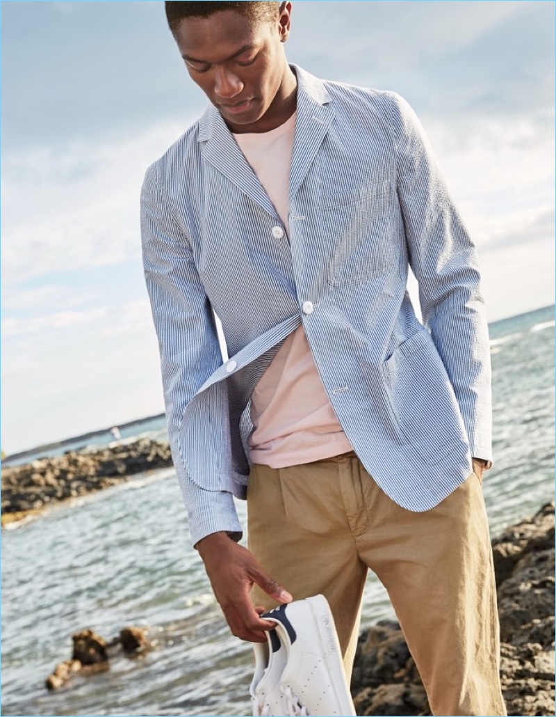 A smart vision, Hamid Onifade wears a J.Crew seersucker blazer $168, broken-in t-shirt $24.50, pleated chinos $79.99, and Adidas Stan Smith sneakers $75.